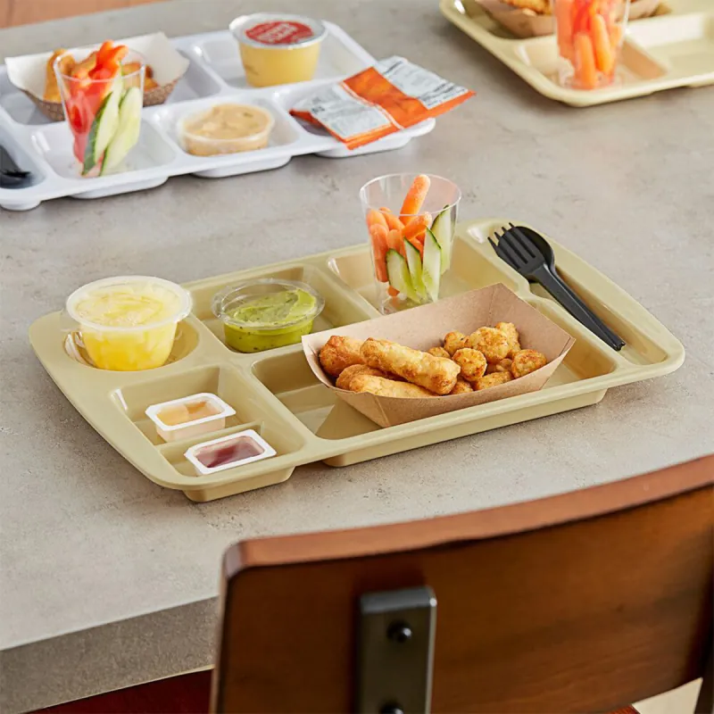 School cafeteria bagasse trays holding served meals on a canteen table