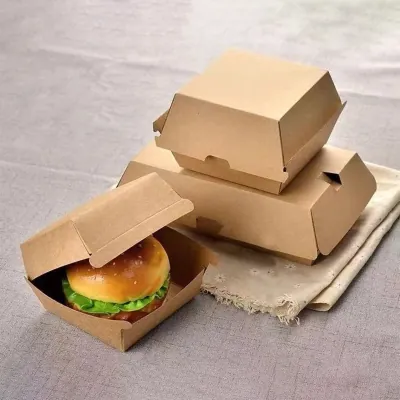 Kraft burger clamshell boxes stacked, one open holding a burger