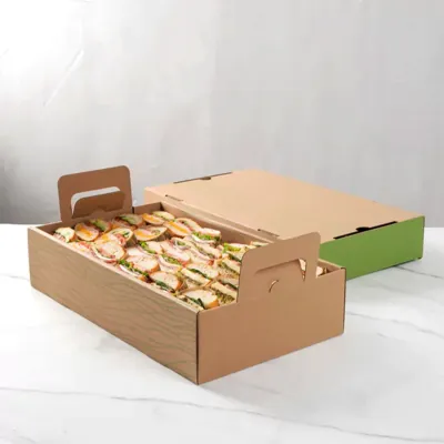 Kraft catering tray filled with sandwich halves, lid partly on