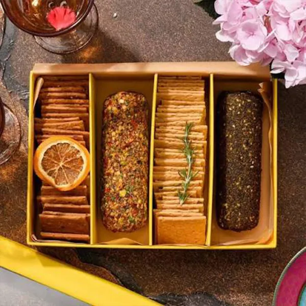Kraft divided tray holding crackers, breadsticks and pâté with a dried orange garnish