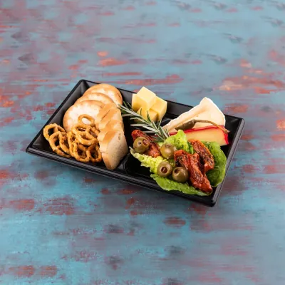 Matt black divided tray holding cheese, crackers, cured meat and fruit