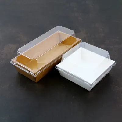 Kraft and white compartment trays with clear lids on a dark surface
