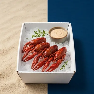 White corrugated tray holding boiled crawfish on ice with a dip pot