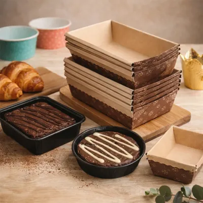 Stacked corrugated food trays in several sizes alongside filled trays of baked goods