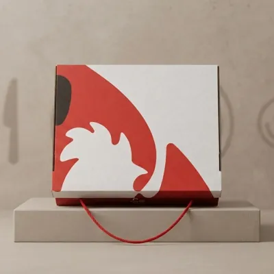 White catering box printed with a bold red rooster design