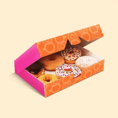 Printed donut box open on a table holding six decorated doughnuts