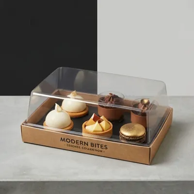 Kraft dessert tray under a clear dome holding individual mousse desserts