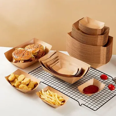 Stack of kraft paper food trays in several sizes beside filled portions of fries and pastries