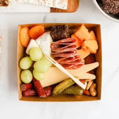 Kraft mini charcuterie tray holding cheese, cured meat, vegetables and dried fruit