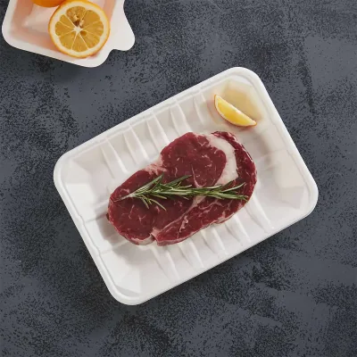 White moulded fibre tray with a ribbed base holding a raw ribeye steak