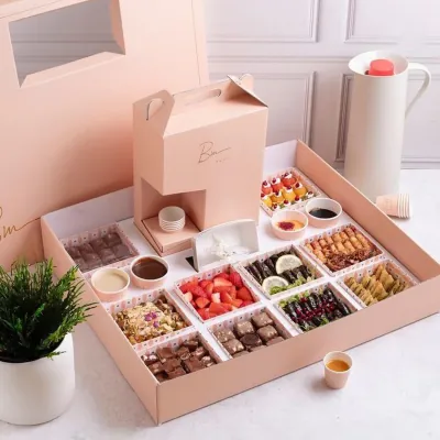Pink rigid compartment platter holding an assortment of sweets and small bakes