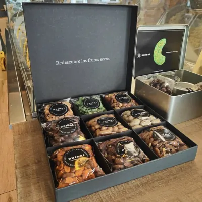 Black rigid catering platter with a lift-off lid holding a compartmented canapé selection