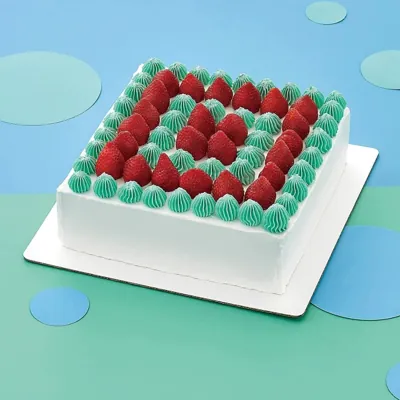 Square celebration cake decorated with raspberries on a white square cake board