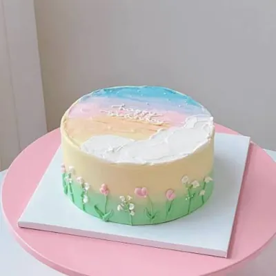 Pastel decorated cake on a white square cake board
