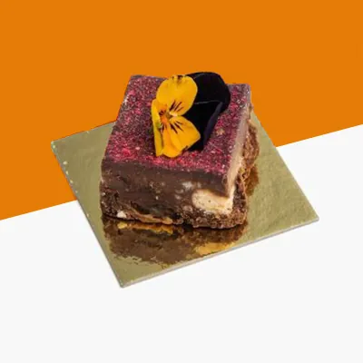 Individual dessert slice on a small gold square cake board