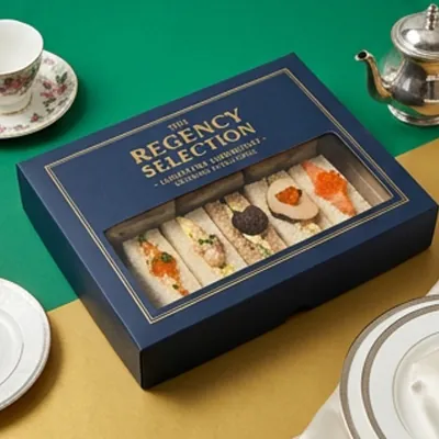 Navy printed tea sandwich box with a window showing a canapé selection
